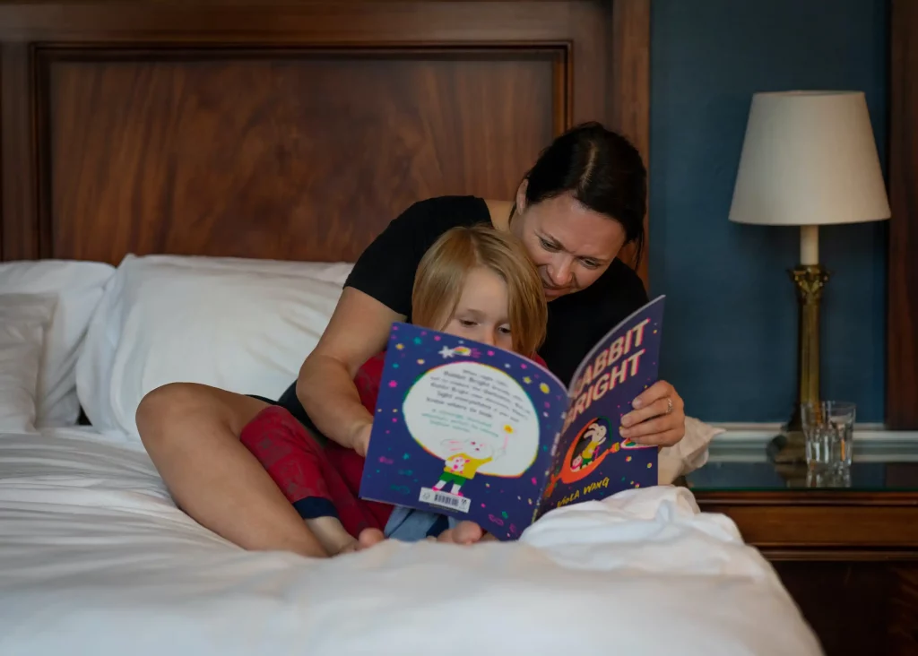 A mum reading her toddler a book before bed