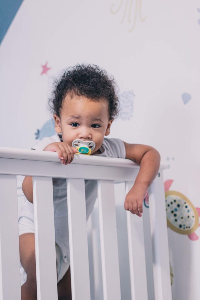 Toddler standing up in a cot