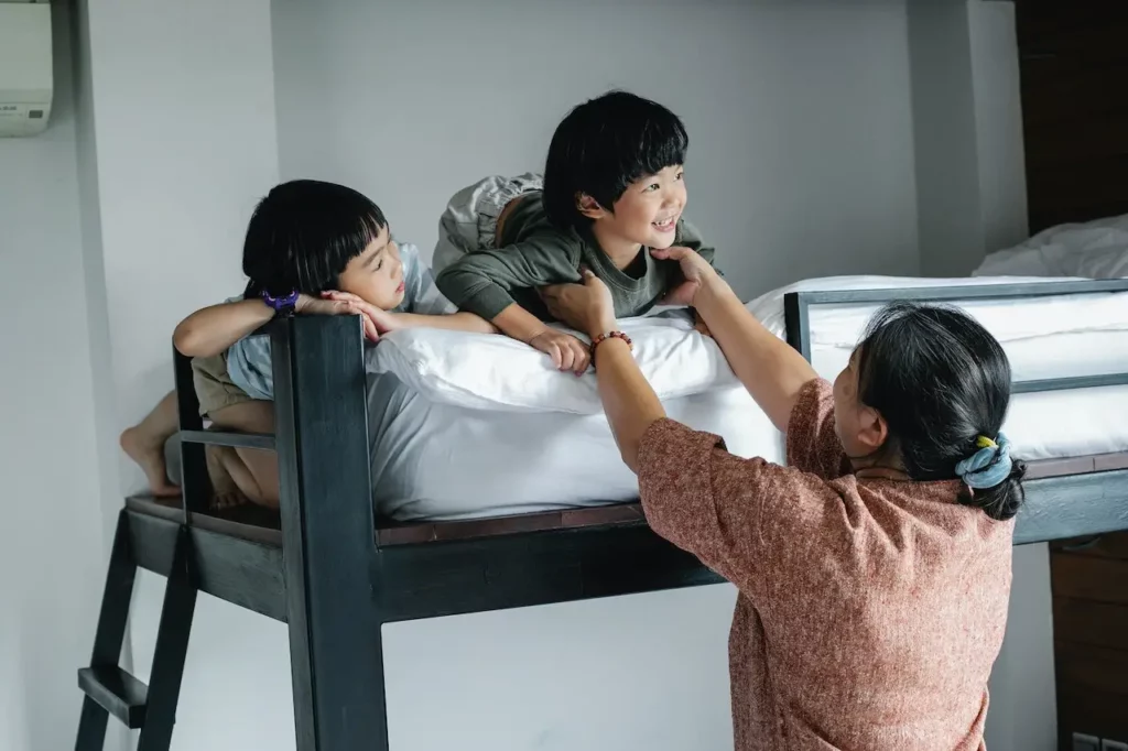 Grandmother helping child down from top bunk